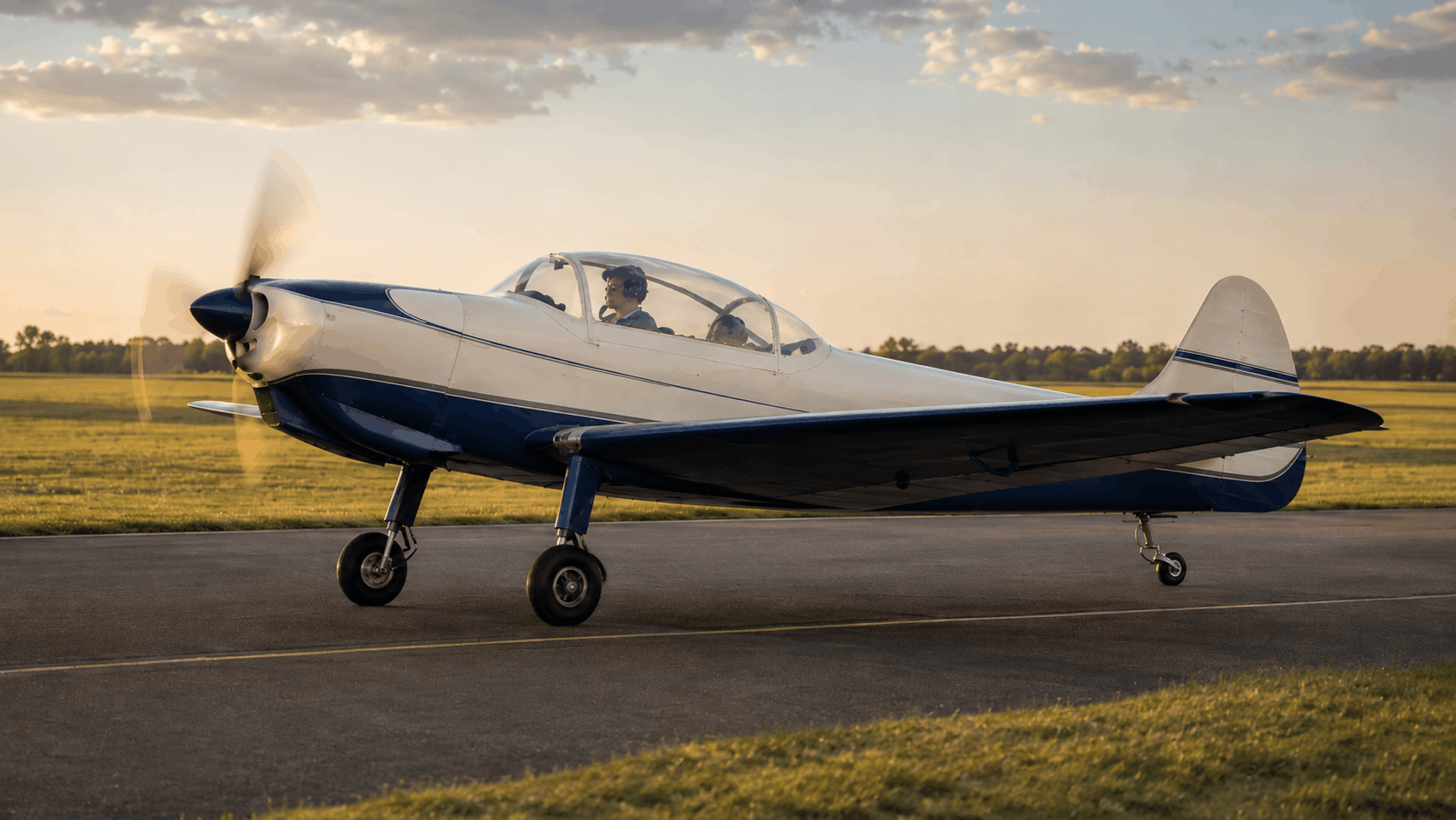 AI-generated editorial image of a UTVA Aero 3-style vintage trainer aircraft on an airfield