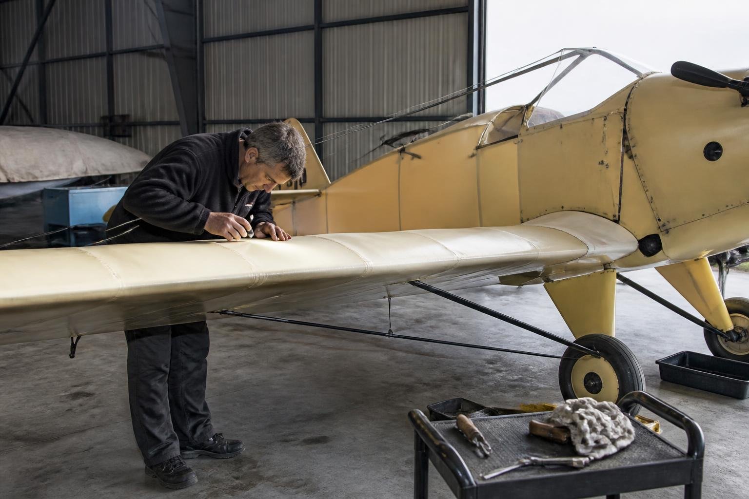 Inspector examining a vintage aircraft in a hangar