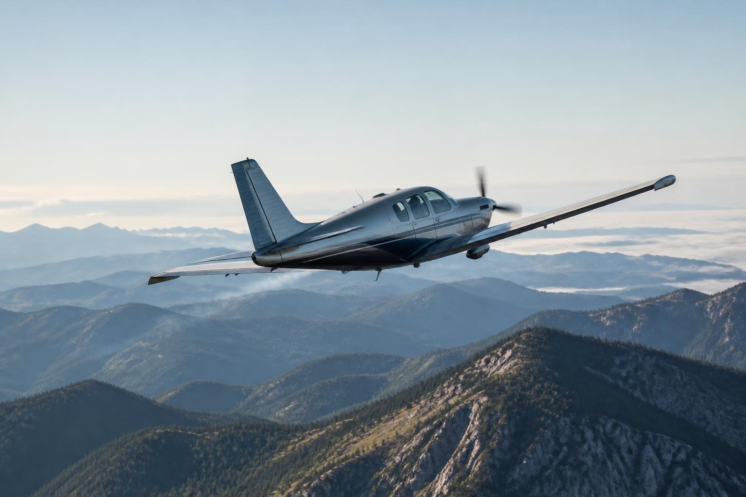 Turbocharged piston aircraft climbing above mountain terrain